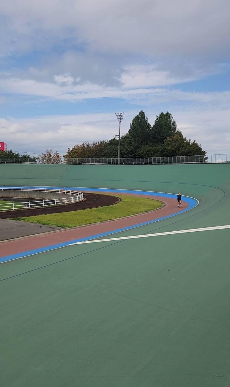緑色のバンクが大きなカーブを描く屋外の競輪場