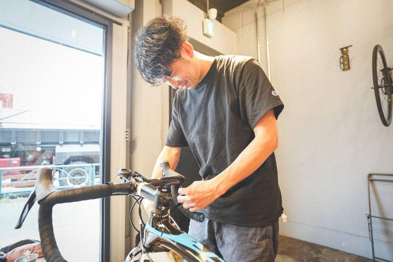 ロードバイクのハンドル周辺を工具で調整している様子